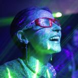 Henkilö katsoo eteenpäin valoon aurinkolasit päässä.