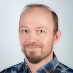 Henkilökuvassa mies katsoo kameraan ja hymyilee.