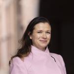 Nikkilä katsoo suoraan kameraan päällään vaaleanpunainen villakangastakki.