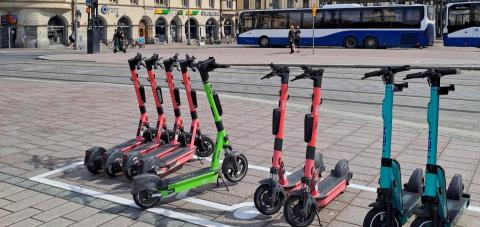 Sähköpotkulaudat rivissä sähköpotkulautojen pysäköintiruudussa.