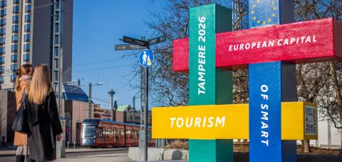 Passersby look at the Smart Tourism Capital statue.