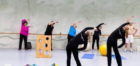 Liikuntaryhmä venyttelemässä ohjaajien johdolla.