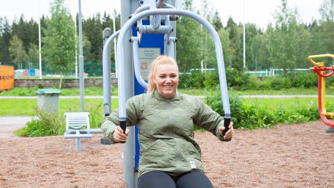 Henkilö treenaa ulkokuntosalilaitteessa.