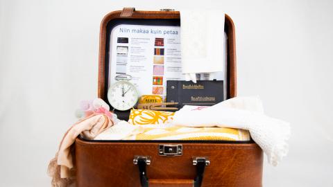 Avonaisen matkalaukun sisällä on lakanoita, papiljotit ja herätyskello.