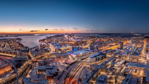 Tampereen keskusta iltahämärässä ilmasta kuvattuna. Keskellä Nokia arena.