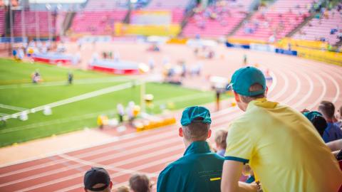 Kaksi ihmistä katsovat urheilukenttää.