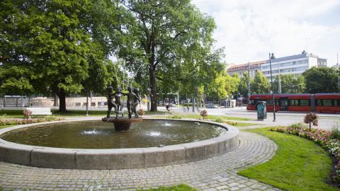 Suihkulähde Pyynikin kirkkopuistossa, taustalla ratikka.