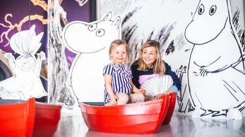 Lapsi punaisessa veneessä ja vanhempi vieressä Muumimuseossa.