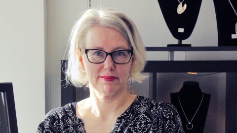 Henkilö pitelee koruja kädessään. Susanna Nurminen.