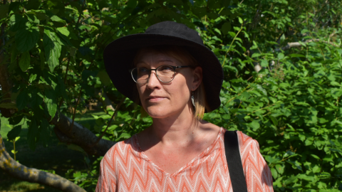 Henkilö pensaan edessä. Laura Tikkanen.