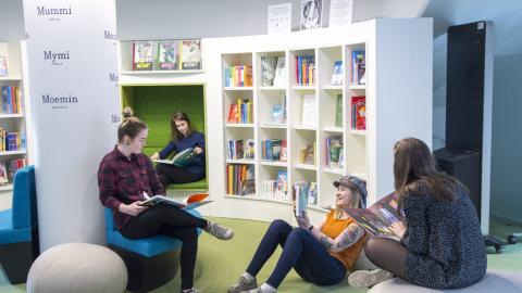 Neljä nuorta lukee ja juttelee lukukirjastossa Muumimuseossa.