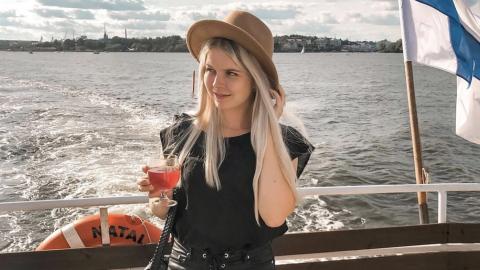 Victoria Laaksonen  veneen perässä Suomen lippu vieressään