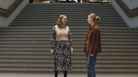 Opettaja Maarit Luhtala ja opiskelija Aliisa Turunen keskustelevat koulun portaiden luona.