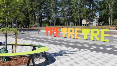 Kalevan liikennepuiston ajoradat ja puistoon sijoitettu Tre tre tre - tekstikyltti.