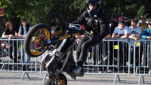 Nuori henkilö keulii mopolla mopomiitissä.