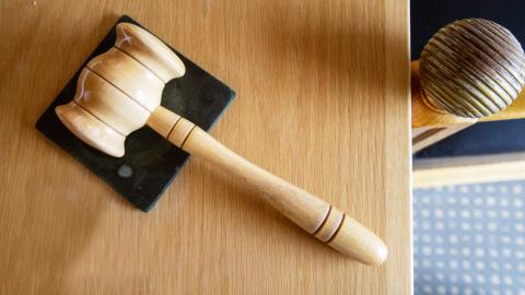 Puinen nuija valtuuston puheenjohtajan pöydällä makaamassa.