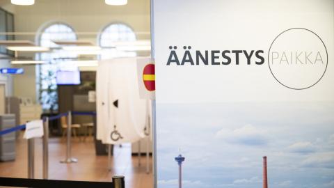 Etualalla panoraamakuva Tampereesta ja kuvassa teksti "äänestyspaikka", taustalla äänestyskoppeja.