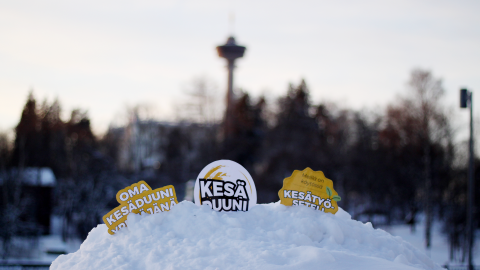 Lumihankeen on upotettu logot Oma kesäduuni yrittäjänä, Kesäduuni ja Kesätyöseteli. Taustalla näkyy sumeana Näsinneula.