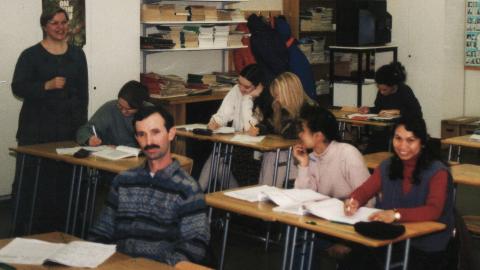 Henkilöt istuvat pulpeteissa kurssilla ja tekevät tehtäviä.