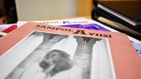 Vanha SampolAviisi-lehti pöydällä. Lehden alla on muita numeroita.