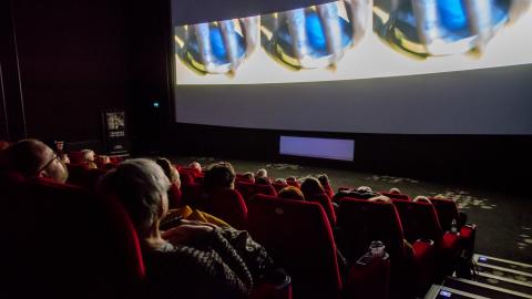 Yleisöä salissa katsomassa elokuvaa.