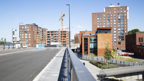 Ranta-Tampellassa kerrostalot rakenteilla. Etualalla silta aurinkoisena päivänä.