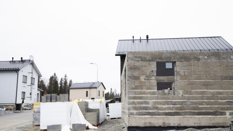 Etualalla rakenteilla oleva talo, taaempana kaksi valmista omakotitaloa.