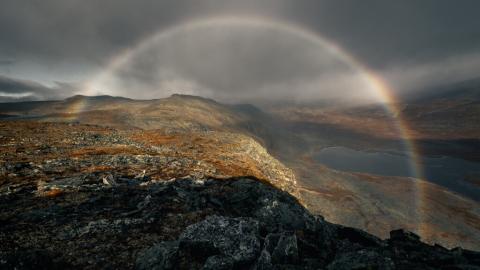 Tunturimaisema, jonka ylle valoilmiö muodostaa kaarevan muodon.