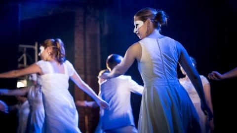 Tanssijoita lavalla vaaleat maskit silmillään.