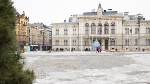 Talvinen, luminen näkymä Tampereen Keskustorilta kohti Raatihuonetta, joka on kuvan taustalla ja esiin nousee rakennuksen edustan torialue.