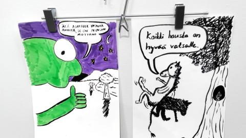 Kaksi nuorten tekemää sarjakuvatyylistä kuvitusta roikkuu housuhenkarista