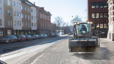 Harjaustraktori puhdistaa jalkakäytävää.