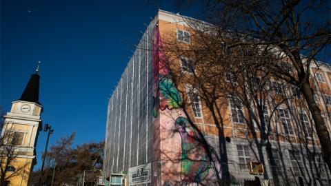 Vasemmalla Vanhan kirkon tapuli -rakennus ja oikealla Kulttuuritalo Laikun kulma, jonka pressussa näkyy rakennuksen kuva sekä lasten taideteoksia.