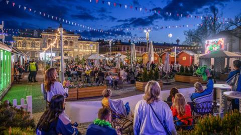 Torille jääkiekkopaidoissa kerääntyneitä ihmisiä tummenevassa illassa.