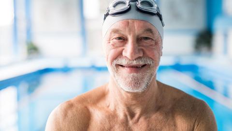 Iloinen seniori uimalakki päässä 