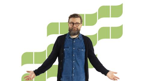 A smiling bearded man with green waves behind him.