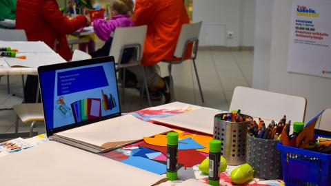 Craft supplies on the table. Next to them is a computer displaying instructions.
