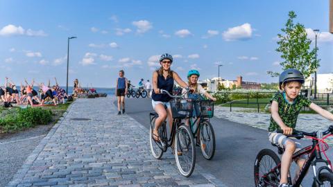 Perhe pyöräilemässä Ranta-Tampellan pyörätiellä kesällä.