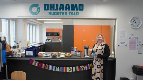 Nainen toimistotilan kahvipisteen edessä.