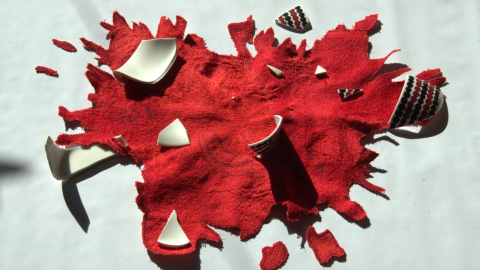 Veistos, joka esittää rikki mennyttä kulhoa ja siitä levinnyttä tomaattikastiketta