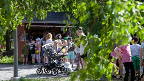 Puistoruokailussa olevia ihmisiä jonossa