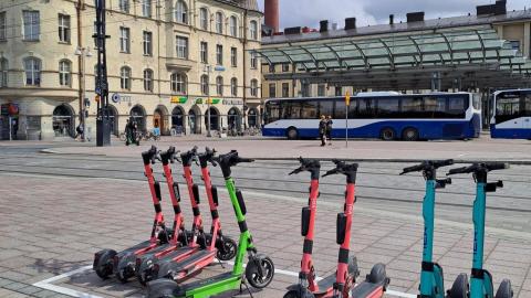 Sähköpotkulaudat rivissä sähköpotkulautojen pysäköintiruudussa.