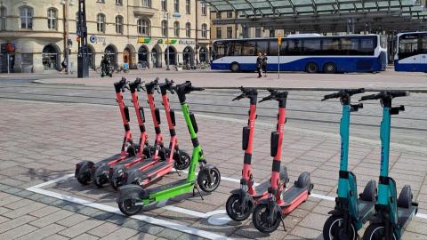 Sähköpotkulaudat rivissä sähköpotkulautojen pysäköintiruudussa.