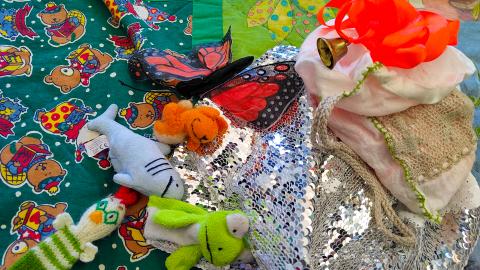 Lorupiiritarvikkeita, kuten pehmoleluja ja kankaita, viltillä.