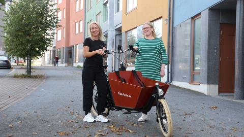 Two people standing with a cargo bike in Vuores.