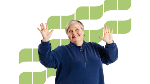 Hymyilevällä naisella on kädet iloisesti pystyssä.