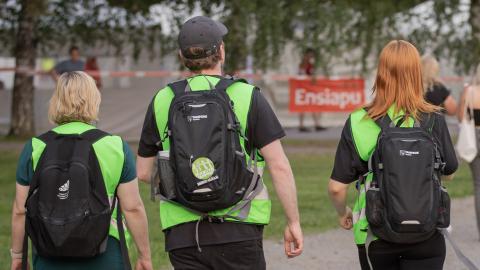 Kolme nuoriso-ohjaajaa jalkautumassa vihreissä liiveissä