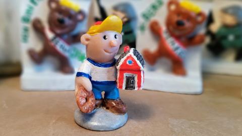 Miniature sculpture representing little boy with a red cabin.