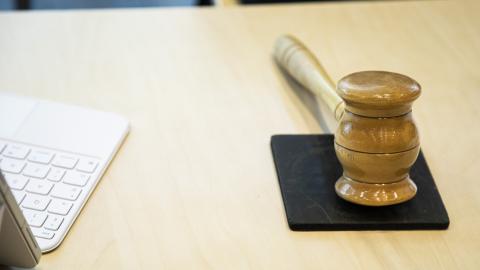 Kuvassa tietokonetta ja puheenjohtajan nuija.