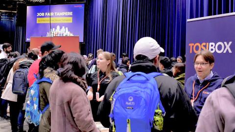 Valokuva Job Fair Tampere -tapahtumasta, jossa työnantajayritykset keskustelevat potentiaalisten työnhakijoiden kanssa.